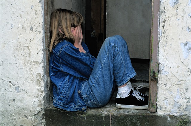 child is sitting, jeans, in the door